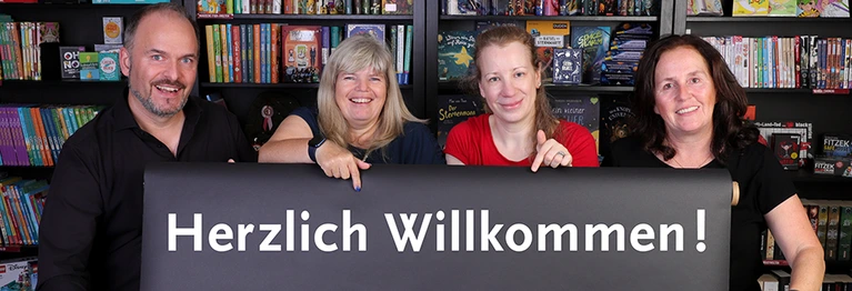 Das Team von SchriftArt, bestehend aus 4 Personen, deutet auf ein Banner mit dem Text "Herzlich Willkommen"