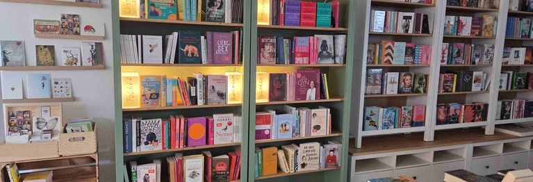 Blick auf die Regale und Postkarten im Beueler Buchladen