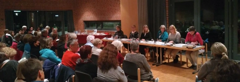 Mitarbeiter der Buchhandlung stellen vor Publikum Bücher vor