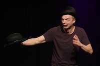 Mensch mit Angst und Hut vor schwarzer Wand