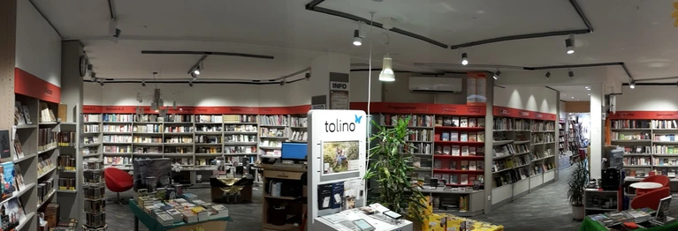 Erdgeschoss der Buchhandlung mit Buchregalen, Arbeitsplatz und Tolinostation