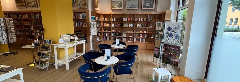 Blick in das Buchcafé mit blau-goldenen Stühlen, Büchern und Spielwaren