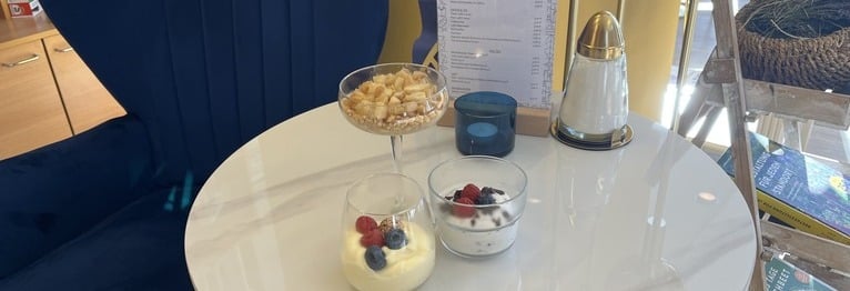 Blick auf drei Süße Gläser: Bratapfelkuchen im Glas, Stracciatella-Creme und Vanille-Mousse mit frischen Beeren