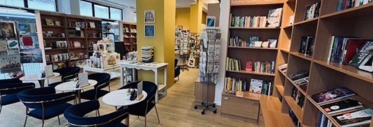Blick in das Buchcafé mit blau-goldenen Stühlen, Büchern und Spielwaren